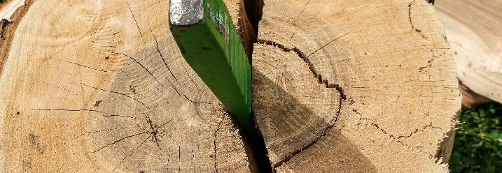 Ein Spaltkeil steckt in einem Stück Holz.